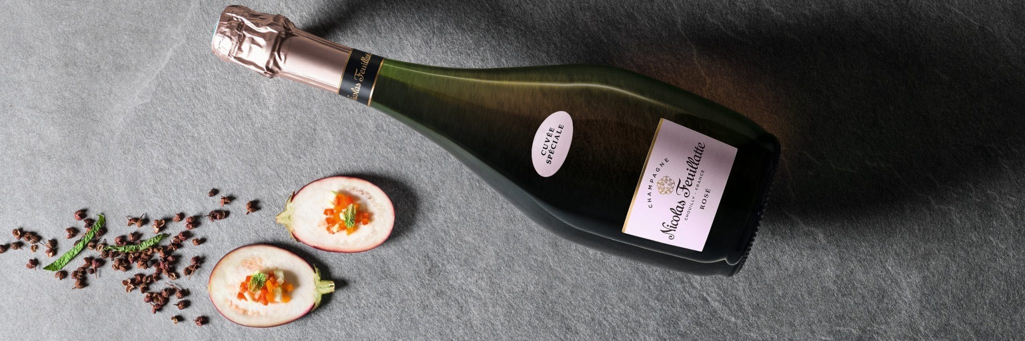 Il y a une bouteille de la marque de champagne Nicolas Feuillatte avec des légumes. Photo de présentation de la page du Kit activation champagne Nicolas Feuillatte et le Cirque du soleil. Support réalisé par l’agence de communication 360 Siouxe, à Paris.